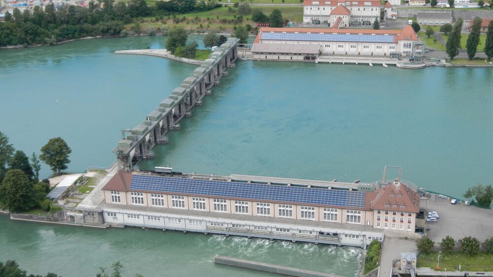 Zwillingskraftwerk: vorne das Wasserkraftwerk KWA in CH-Augst BL am linken Rhein-Ufer, gegenüber das KW von D-Wyhlen am rechten Ufer. Die AEW-Wärmezentrale entsteht in der Maschinenhalle des KW Augst. (Fotos: AEW, KWA/Axpo)